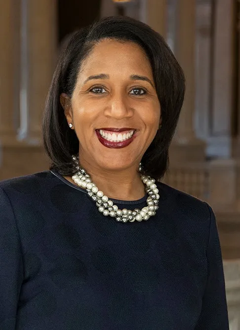 Karyn Temple dressed in a dark top while wearing multicolored pearls 